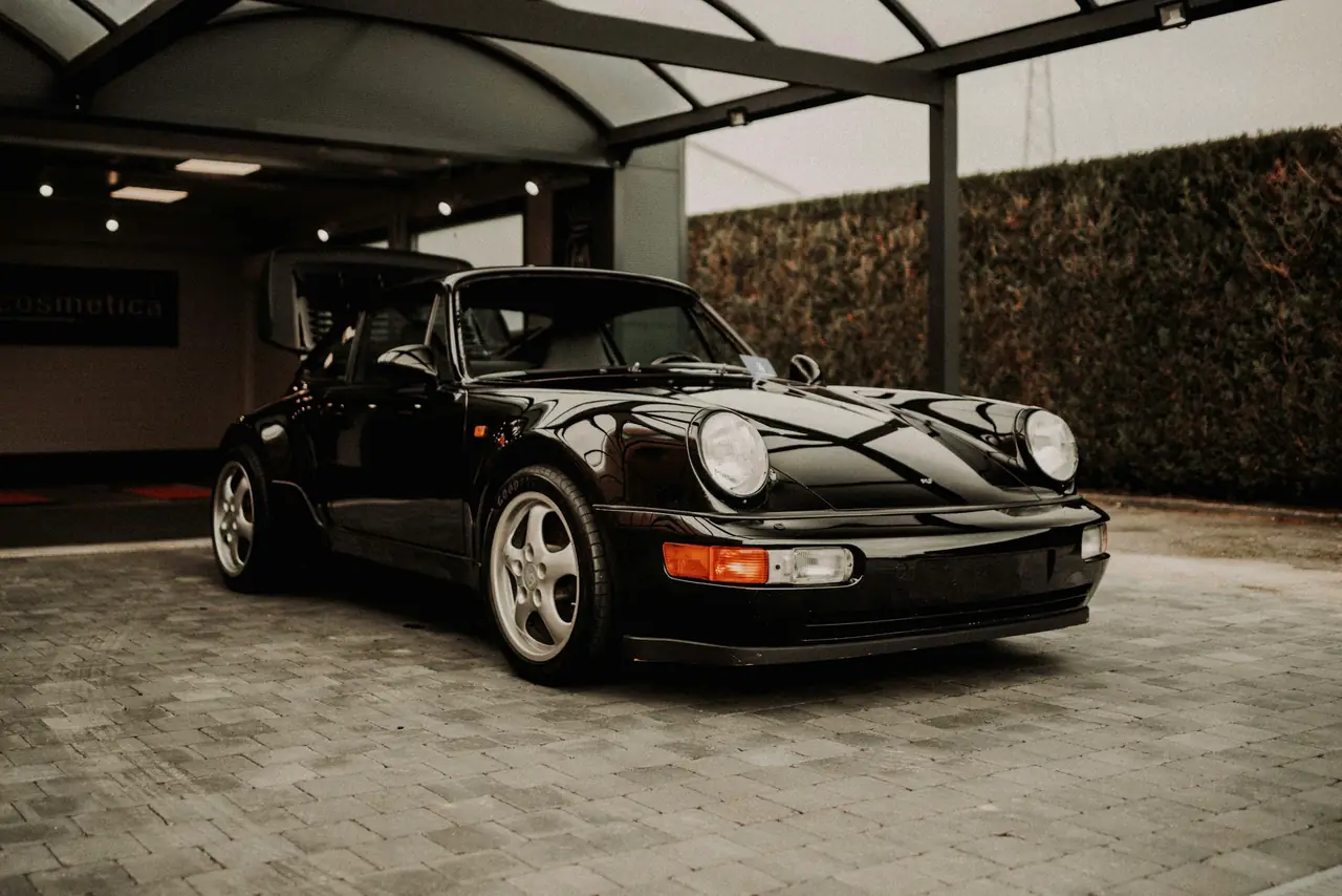 Porsche 911 classique noire garée sous un auvent